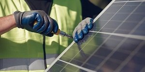 Photovoltaik: jemand verschraubt ein Solarpanel