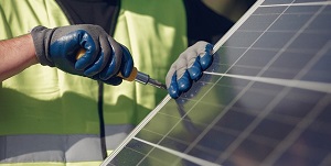 Photovoltaik: jemand verschraubt ein Solarpanel